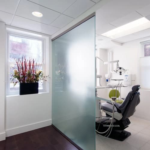 Brookline Dental Center team member speaking with a patient in a treatment room.